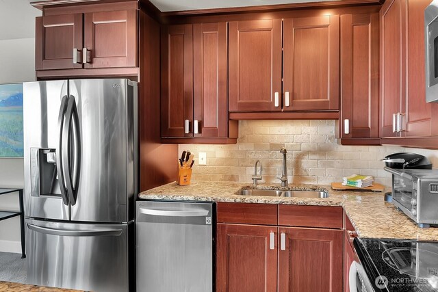 500 W Olympic Pl Unit 401, Seattle, WA 98119 - kitchen featuring appliances with stainless steel finishes, backsplash, light stone countertops, and brown cabinets