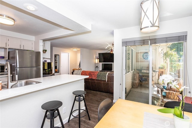 4231 NE 5th St Unit C102, Renton, WA 98059 - kitchen with stainless steel appliances, a kitchen breakfast bar, light countertops, dark wood finished floors, and open floor plan