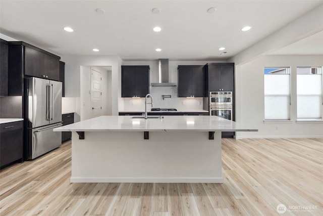 12619 176th St E, Puyallup, WA 98374 - kitchen featuring stainless steel appliances, wall chimney range hood, backsplash, a breakfast bar, and recessed lighting