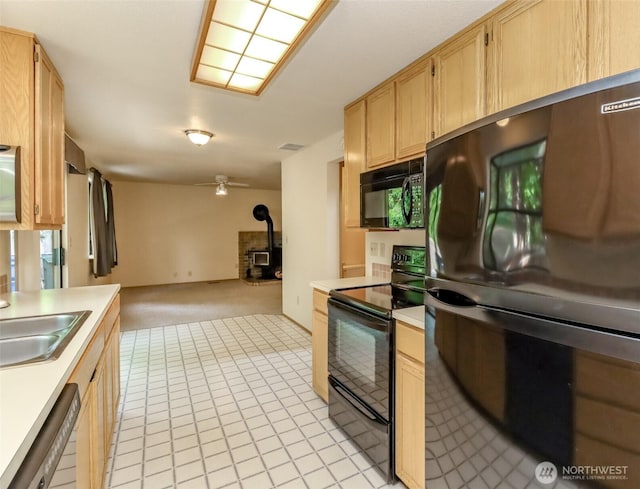 16410 92nd Ave E, Puyallup, WA 98375 - kitchen featuring black appliances, a wood stove, light countertops, and light brown cabinets