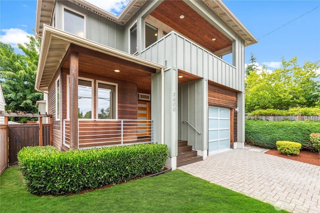 3800 SW Holden St, Seattle, WA 98126 - view of exterior entry featuring a balcony, board and batten siding, a garage, and decorative driveway