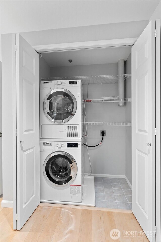 3800 SW Holden St, Seattle, WA 98126 - laundry area with stacked washer / dryer and wood finished floors