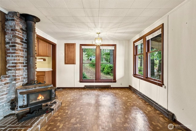 2120 E Spencer Lake Rd, Shelton, WA 98584 - unfurnished living room featuring a wood stove and a chandelier