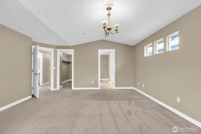 18527 97th Ave E, Puyallup, WA 98375 - unfurnished bedroom featuring a chandelier, lofted ceiling, a walk in closet, and carpet flooring
