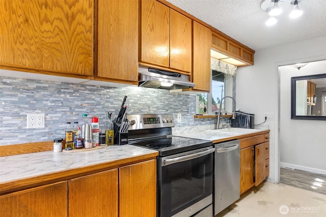 1401 Lum Rd, Centralia, WA 98531 - kitchen with appliances with stainless steel finishes, under cabinet range hood, light countertops, tasteful backsplash, and a textured ceiling