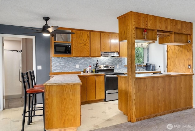 1401 Lum Rd, Centralia, WA 98531 - kitchen with electric stove, under cabinet range hood, open shelves, a peninsula, and a textured ceiling