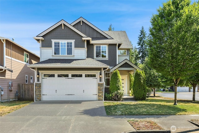 1803 65th Ct SE, Tumwater, WA 98501 - craftsman-style home featuring driveway, an attached garage, a shingled roof, stone siding, and board and batten siding
