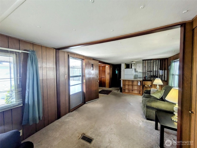 2302 R St SE Unit 108, Auburn, WA 98002 - living room with light carpet, wooden walls, and healthy amount of natural light