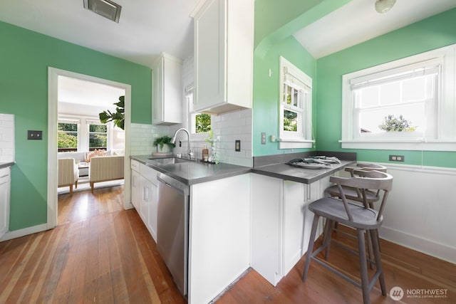 2110 N 88th St, Seattle, WA 98103 - kitchen featuring stainless steel dishwasher, white cabinets, dark countertops, and hardwood / wood-style floors