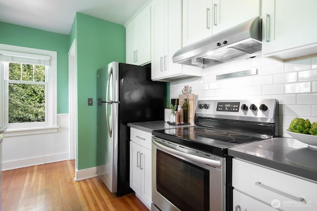 2110 N 88th St, Seattle, WA 98103 - kitchen featuring appliances with stainless steel finishes, under cabinet range hood, backsplash, white cabinets, and light wood-style floors
