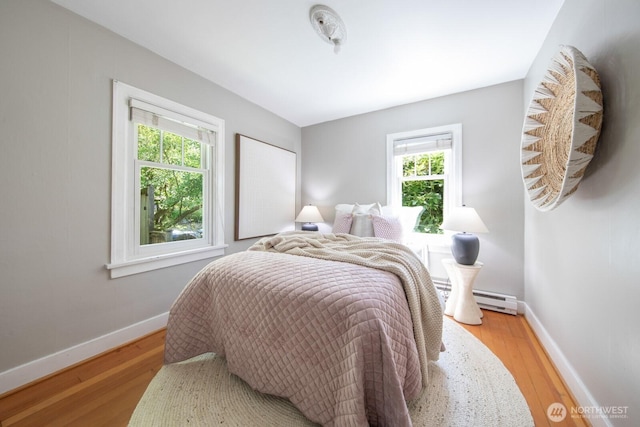 2110 N 88th St, Seattle, WA 98103 - bedroom with wood finished floors and a baseboard heating unit
