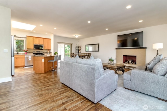 502 SW 326th St, Federal Way, WA 98023 - living area with light wood-type flooring, recessed lighting, a skylight, and a fireplace