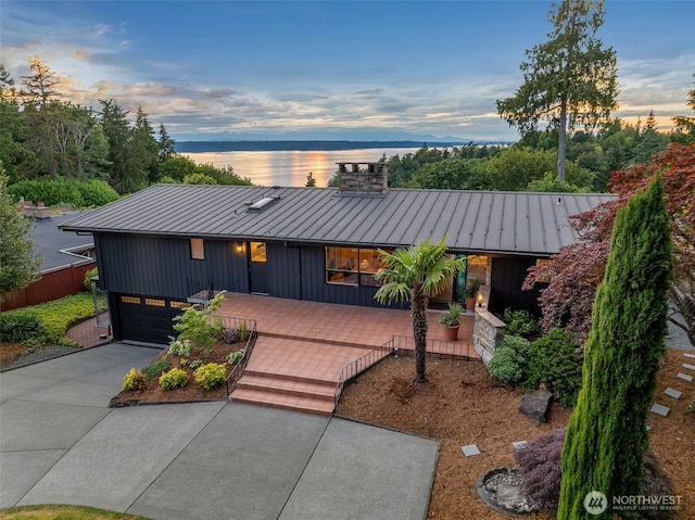 432 SW 206th St, Normandy Park, WA 98166 - view of front of property with a standing seam roof, a metal roof, concrete driveway, an attached garage, and a chimney
