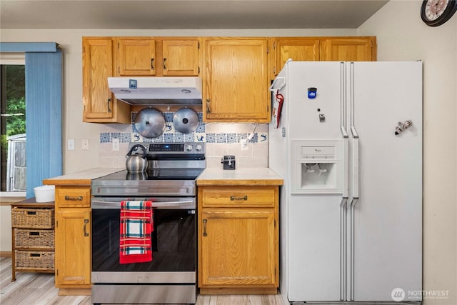 5626 29th Ct SE, Lacey, WA 98503 - kitchen featuring white refrigerator with ice dispenser, stainless steel electric range, under cabinet range hood, light countertops, and decorative backsplash