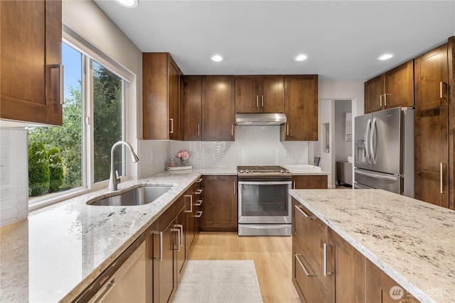 21206 9th Ave SE, Bothell, WA 98021 - kitchen with stainless steel appliances, under cabinet range hood, light stone countertops, recessed lighting, and light wood-style floors