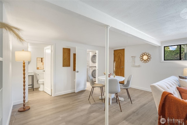 13247 2nd Ave NW, Seattle, WA 98177 - dining room featuring stacked washing machine and dryer, light wood-style flooring, and a textured ceiling