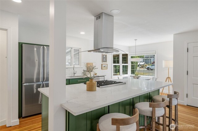13247 2nd Ave NW, Seattle, WA 98177 - kitchen with stainless steel appliances, green cabinets, island exhaust hood, light wood-style floors, and recessed lighting
