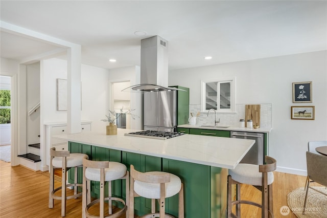 13247 2nd Ave NW, Seattle, WA 98177 - kitchen featuring green cabinetry, island range hood, a breakfast bar area, light wood-type flooring, and decorative backsplash