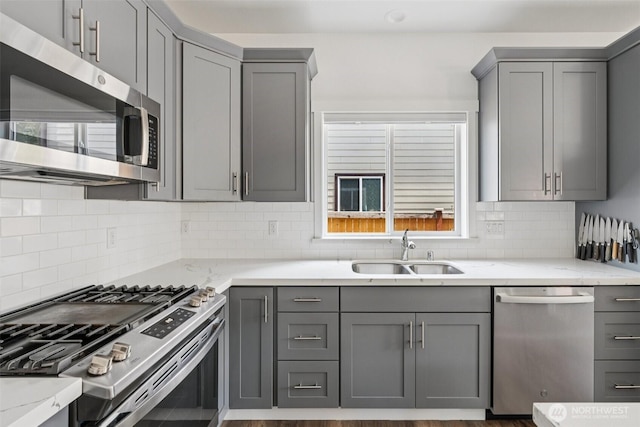 8665 Kimmie Loop SW, Tumwater, WA 98512 - kitchen with stainless steel appliances, gray cabinetry, light stone countertops, and decorative backsplash
