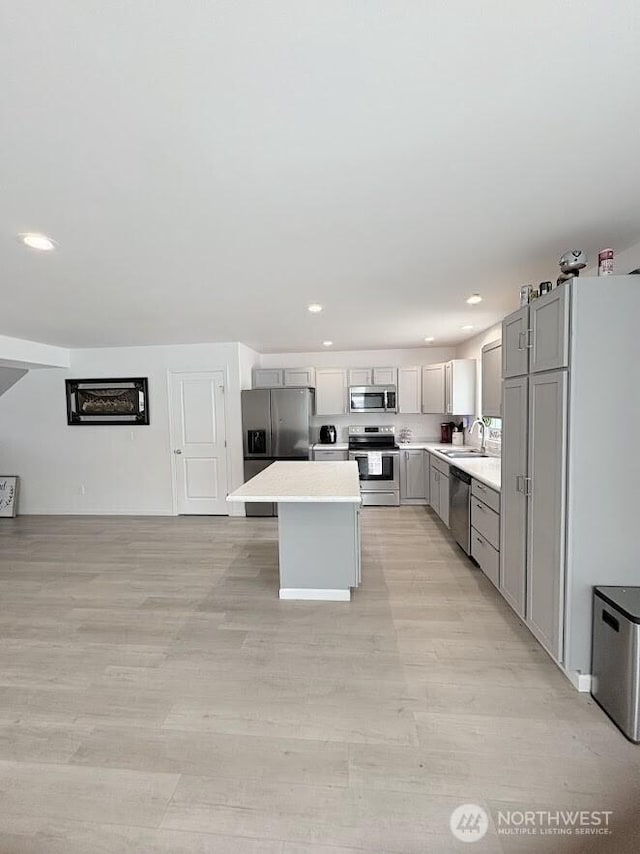 1344 Theo Way, Rock Island, WA 98850 - kitchen featuring stainless steel appliances, gray cabinetry, a kitchen island, light countertops, and light wood-type flooring