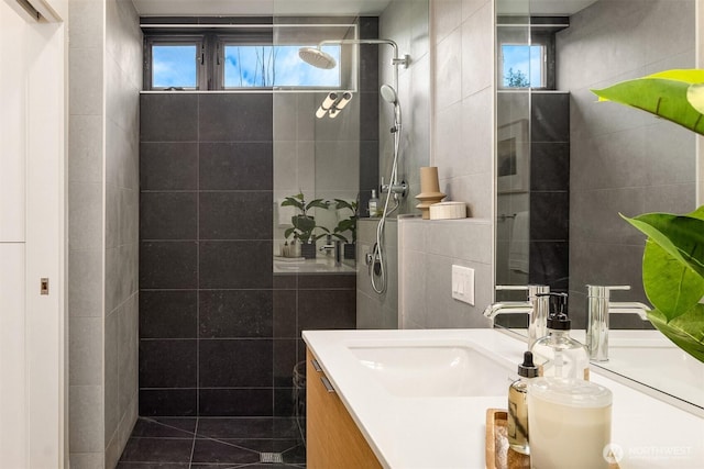 228 Canopy Path NW, Bainbridge Island, WA 98110 - bathroom featuring tile walls, vanity, a walk in shower, healthy amount of natural light, and tile patterned flooring