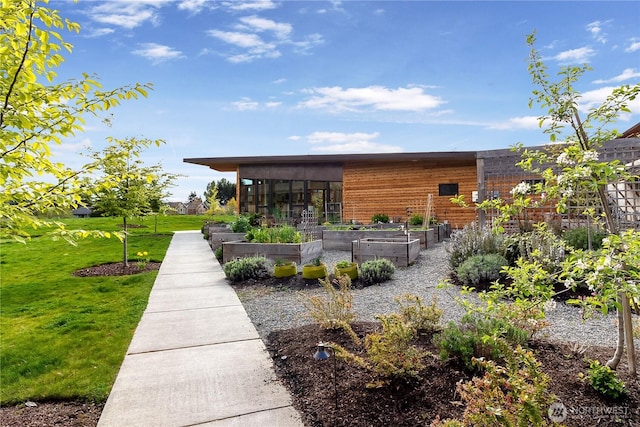 228 Canopy Path NW, Bainbridge Island, WA 98110 - back of property with a vegetable garden, a yard, and a sunroom