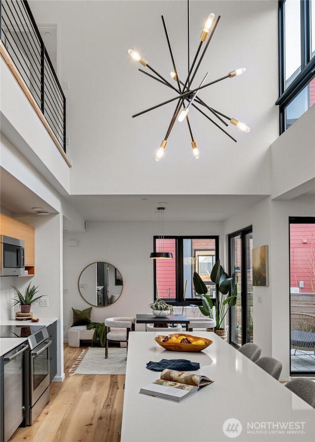 228 Canopy Path NW, Bainbridge Island, WA 98110 - dining room featuring light wood-style floors, a high ceiling, and a chandelier