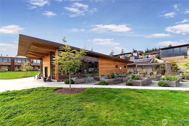 228 Canopy Path NW, Bainbridge Island, WA 98110 - rear view of property with a vegetable garden, a lawn, and solar panels
