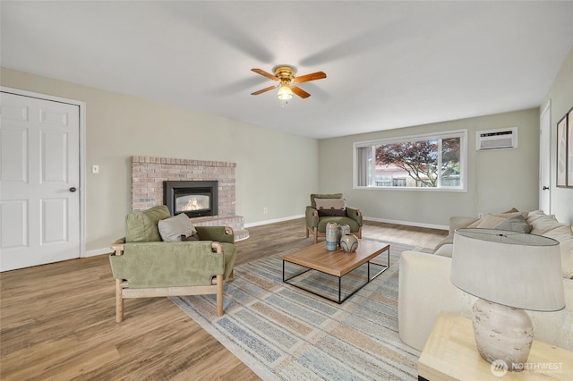 120 E Mason Ave, Buckley, WA 98321 - living area with a ceiling fan, wood finished floors, a wall mounted AC, and a brick fireplace