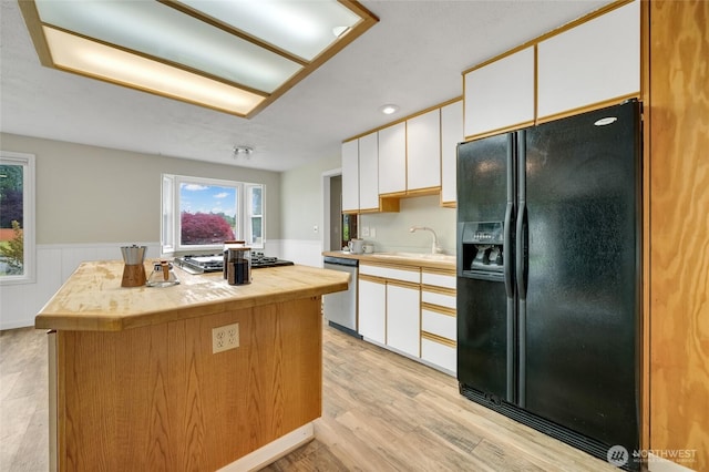 120 E Mason Ave, Buckley, WA 98321 - kitchen with black refrigerator with ice dispenser, dishwasher, cooktop, light wood-type flooring, and wainscoting