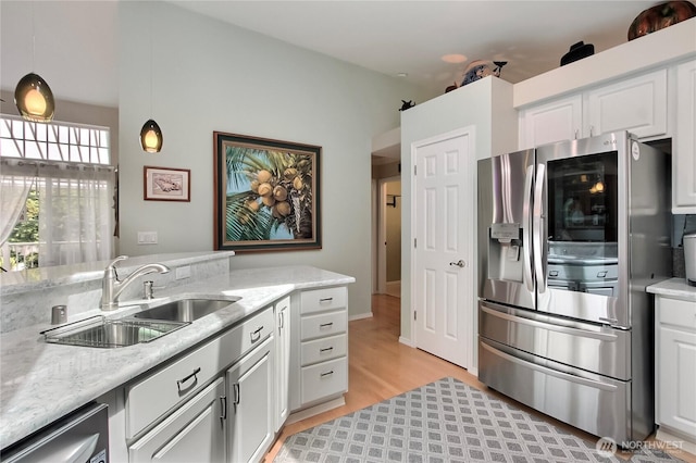 2237 Mcdonald Ave, Dupont, WA 98327 - kitchen with stainless steel appliances, light wood-style flooring, white cabinetry, and light stone counters