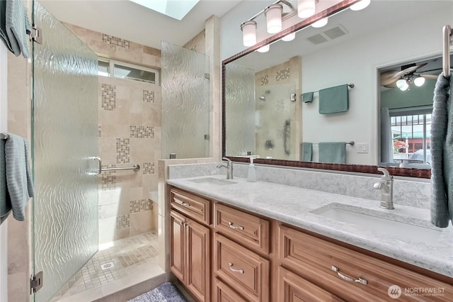 2237 Mcdonald Ave, Dupont, WA 98327 - bathroom featuring a stall shower, double vanity, ceiling fan, and a skylight