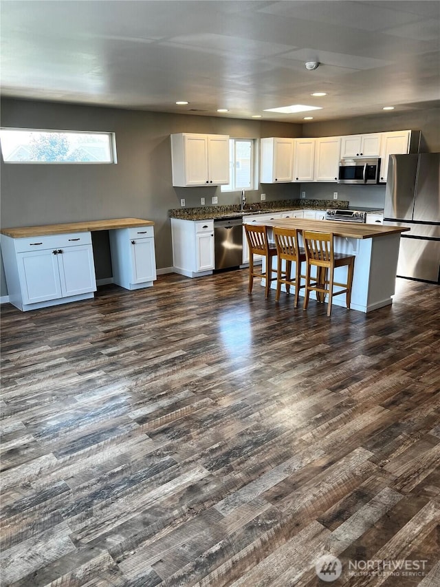 1042 S Lakeland Dr, Moses Lake, WA 98837 - kitchen featuring stainless steel appliances, wooden counters, white cabinets, recessed lighting, and a breakfast bar