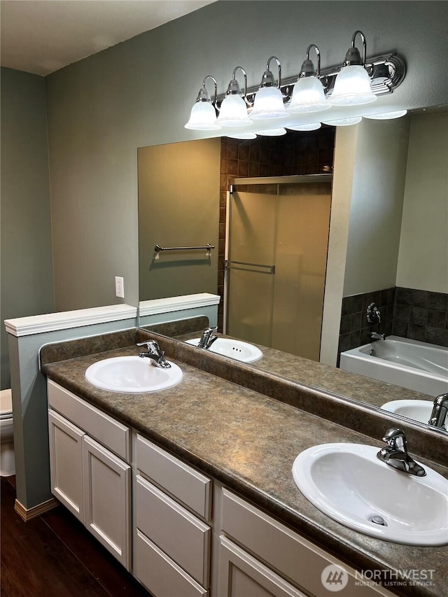 1042 S Lakeland Dr, Moses Lake, WA 98837 - full bathroom with double vanity, a garden tub, a stall shower, and wood finished floors