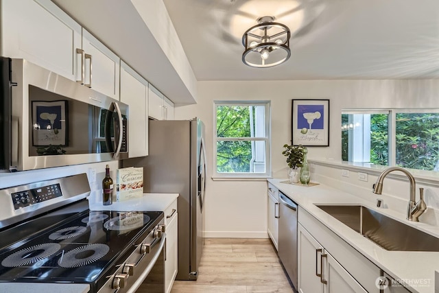 5589 Lakemont Blvd SE Unit 1703, Bellevue, WA 98006 - kitchen featuring appliances with stainless steel finishes, light wood-type flooring, and light countertops
