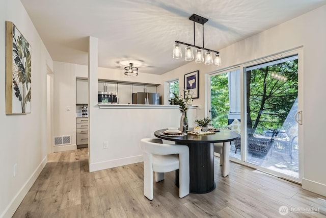 5589 Lakemont Blvd SE Unit 1703, Bellevue, WA 98006 - dining room featuring light wood-type flooring and plenty of natural light