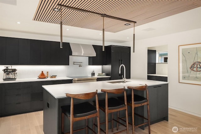 2241 Fairview Ave E Unit B, Seattle, WA 98102 - kitchen with exhaust hood, dark cabinetry, light countertops, modern cabinets, and light wood-style flooring