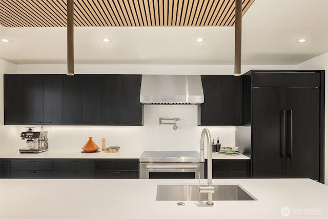2241 Fairview Ave E Unit B, Seattle, WA 98102 - kitchen featuring dark cabinets, wall chimney exhaust hood, light countertops, range, and recessed lighting