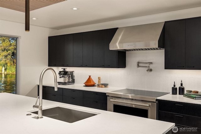2241 Fairview Ave E Unit B, Seattle, WA 98102 - kitchen featuring dark cabinets, wall chimney exhaust hood, electric range, light countertops, and recessed lighting