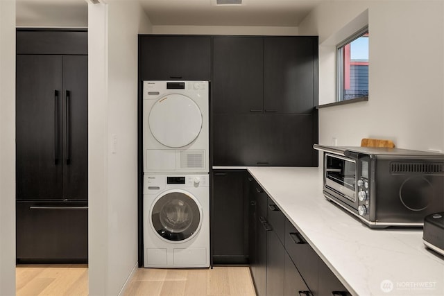 2241 Fairview Ave E Unit B, Seattle, WA 98102 - washroom featuring stacked washer / dryer and light wood-style floors