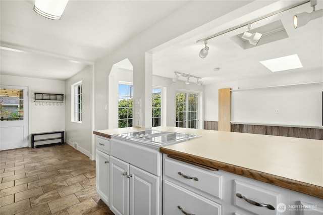 1037 Harding St, Enumclaw, WA 98022 - kitchen featuring a skylight, white cabinetry, stone finish flooring, light countertops, and electric stovetop