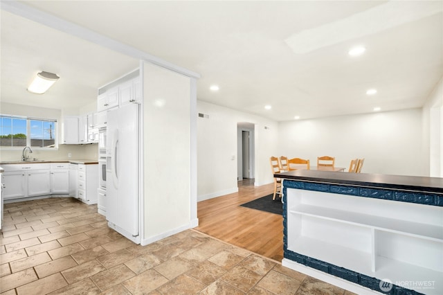 1037 Harding St, Enumclaw, WA 98022 - kitchen with white appliances, white cabinetry, recessed lighting, light countertops, and light stone finish floors