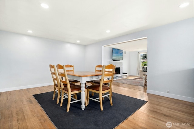 1037 Harding St, Enumclaw, WA 98022 - dining space with wood finished floors, recessed lighting, and a fireplace with raised hearth