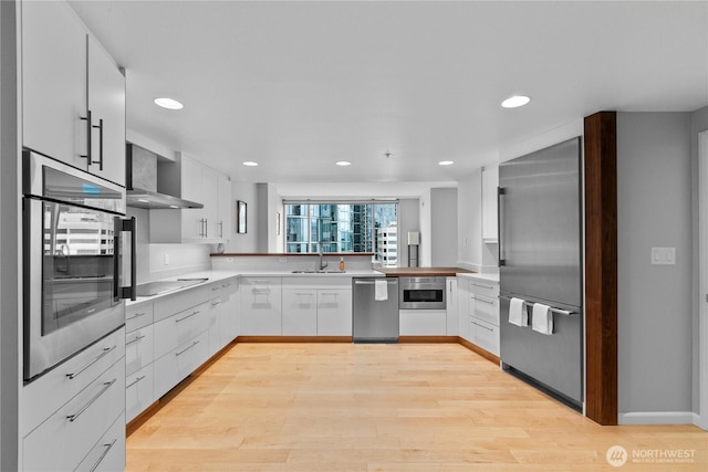 177 NE 107th Ave Unit 1601, Bellevue, WA 98004 - kitchen featuring appliances with stainless steel finishes, wall chimney range hood, light countertops, recessed lighting, and white cabinets
