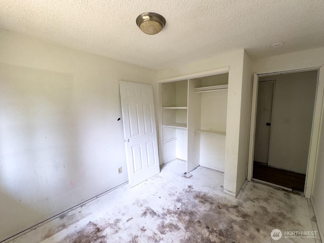 6420 NE Nelson St, Suquamish, WA 98392 - unfurnished bedroom with a closet, a textured ceiling, and concrete floors