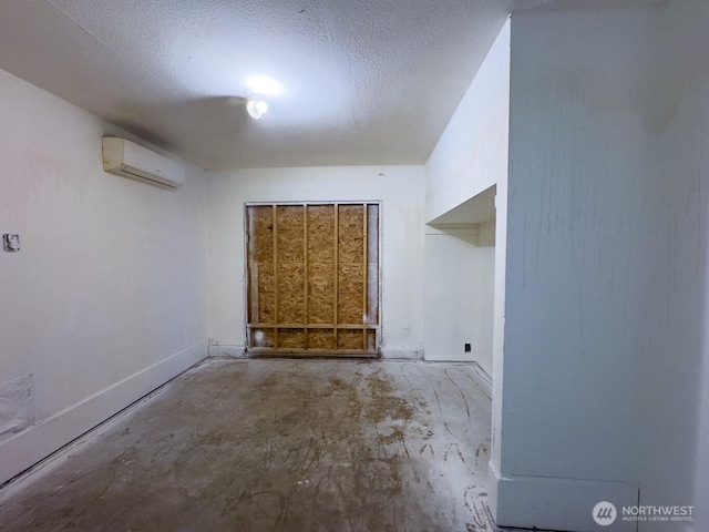 6420 NE Nelson St, Suquamish, WA 98392 - spare room featuring a wall mounted AC, concrete floors, and a textured ceiling
