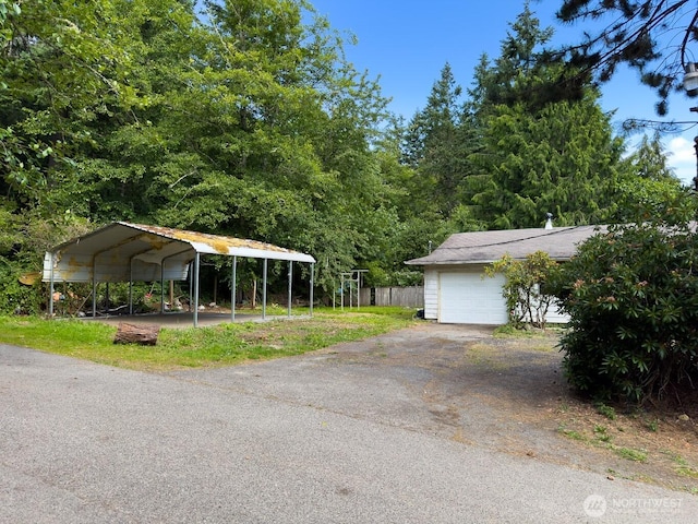 6420 NE Nelson St, Suquamish, WA 98392 - garage featuring asphalt driveway and a detached carport