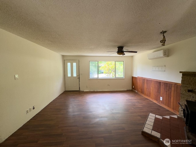 6420 NE Nelson St, Suquamish, WA 98392 - unfurnished living room with dark wood-type flooring, an AC wall unit, ceiling fan, a textured ceiling, and a wainscoted wall