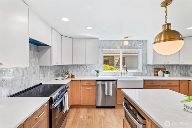 7006 20th Ave NE, Seattle, WA 98115 - kitchen featuring appliances with stainless steel finishes, light countertops, white cabinets, decorative backsplash, and recessed lighting