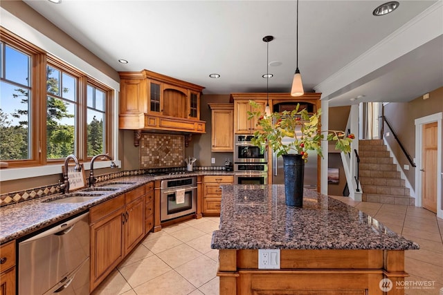 6730 Forest Ridge Dr, Wenatchee, WA 98801 - kitchen featuring appliances with stainless steel finishes, light tile patterned floors, brown cabinetry, dark stone countertops, and recessed lighting